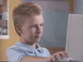 Animated gif of a kid working on a computer that's old enough to use a CRT monitor - the kid's giving the viewer the thumbs up.