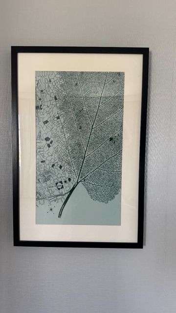An art piece which has a map of city blocks on one side which transform into the cells of a leaf on the other.